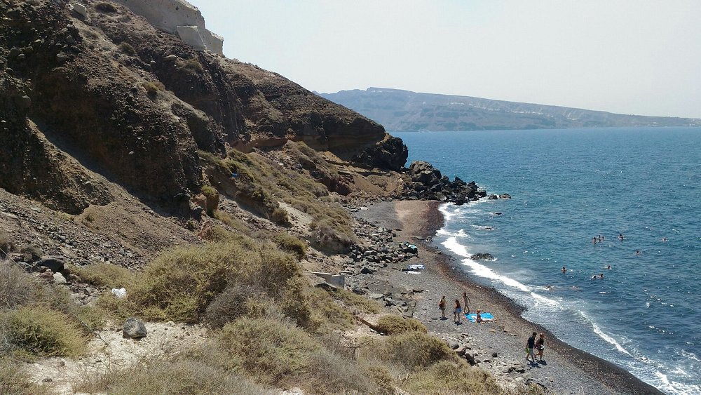 Katharos Beach near Oia Santorini wild black pebble beach with sunset view