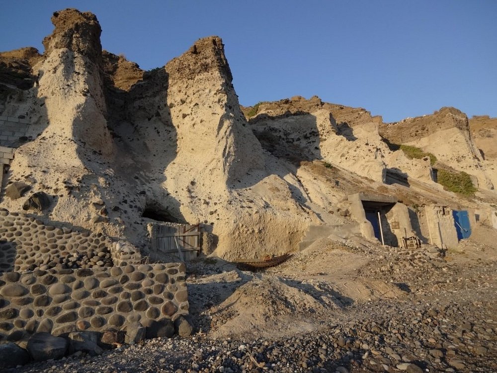Mesa Pigadia Black Beach Santorini sheltered cove with fishing boats and clear water